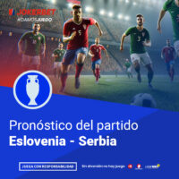 La Imagen Muestra A Jugadores De Los Equipos De Eslovenia Y Serbia En Acción En Un Estadio Iluminado Y Lleno De Espectadores. En La Parte Inferior, Dentro De Un Recuadro Azul, Se Lee El Texto 