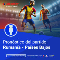 La Imagen Muestra A Jugadores De Los Equipos De Rumanía Y Países Bajos En Un Estadio Iluminado Y Lleno De Espectadores. Los Jugadores Están En Plena Acción, Con El Balón En El Campo. En La Parte Inferior, Dentro De Un Recuadro Azul, Se Lee El Texto 
